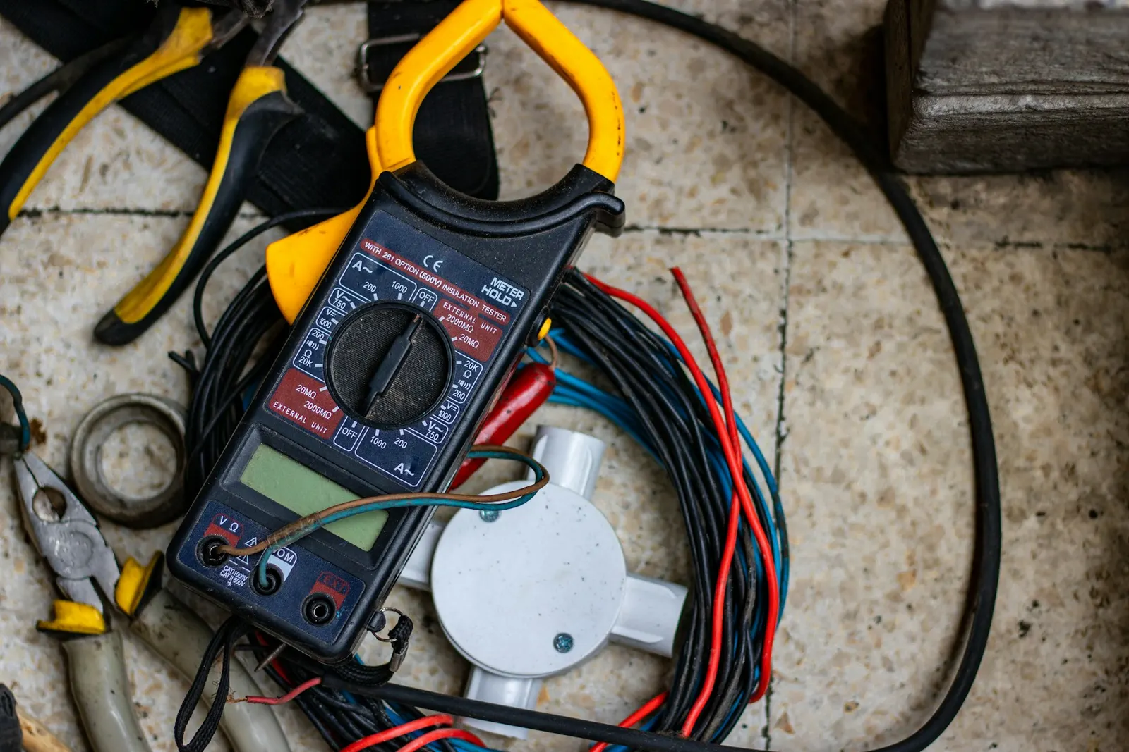 Pinza amperimétrica sobre cables de un tablero, lista para medir consumo eléctrico