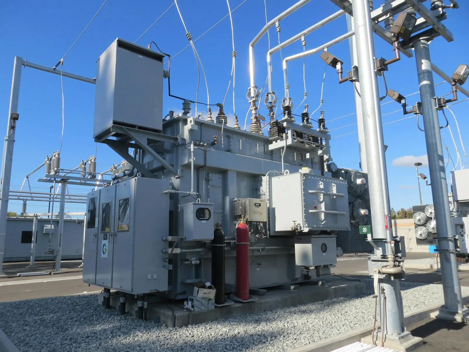 Transformador eléctrico de gran tamaño en una subestación, bajo cielo despejado